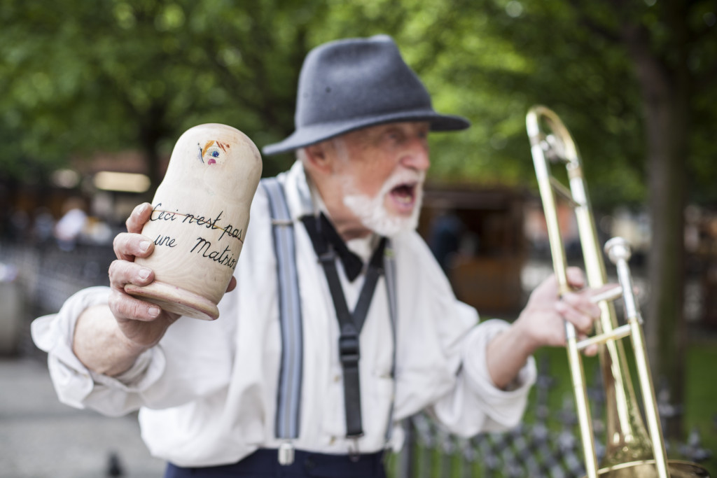 An eccentric Czech jazz musician dancing in the vicinity of the Old Town Square next to one of the pinhole Matrioskas.